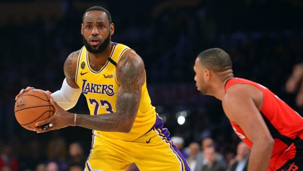 Los Angeles Lakers forward LeBron James controls the ball against Houston Rockets guard Eric Gordon during a game at Staples Center.
